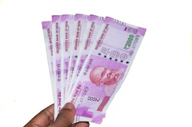Seçici Odak: Beyaz arka planda Hint 2000 rupi 'lik banknotlarla el ele tutuşmak. Yeni Rupi 2000 banknotunun kapağını kapatın..