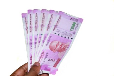 Seçici Odak: Beyaz arka planda Hint 2000 rupi 'lik banknotlarla el ele tutuşmak. Yeni Rupi 2000 banknotunun kapağını kapatın..