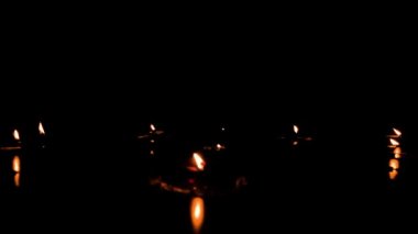 Diya - lambalar Diwali festivali sezonunda yaktı. Siyah arka plan üzerine yanan kandil grubu. Gerçek kızıl alevler ile karanlıkta ışık mumlar. Üst metin için yer yer kopyalayın.