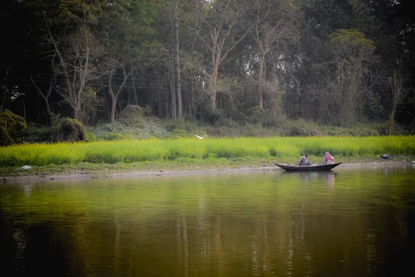 Kumari River front , Mukutmanipur Dam in Purulia West Bengal, India December 15, 2018: Fisherman sitting on a wooden boat in evening time. A beautiful landscape of rural Indian coastal village life.