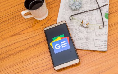 Kolkata, Hindistan, 3 Şubat 2019: Google haber app (uygulama) güzel bir gazete ve bir fincan kahve ile ahşap bir masa üzerine yerleştirilen cep telefonu ekranda görünür. Bir teknoloji ürün çekimi.