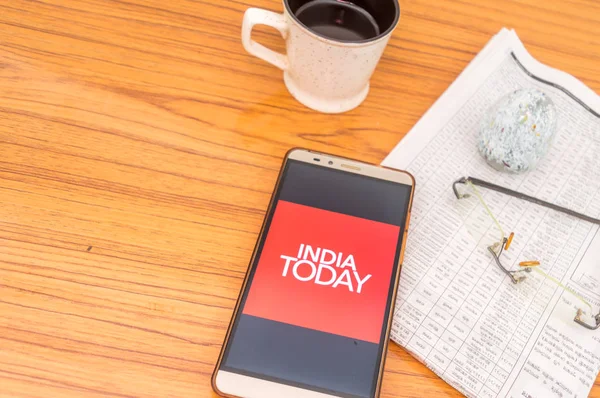 Kolkata, Inde, 3 février 2019 : India Today app (application) visible sur l'écran de téléphone portable superbement placé sur une table en bois avec du journal et une tasse de café. Un tir de produit technologique . — Photo