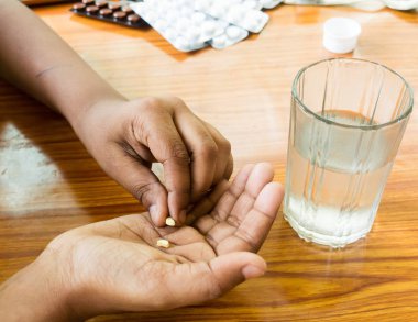 Doktorun önerdiği gibi evde kendi kendini tedavi. Eline ilaç döken bir adama yaklaş. Tıbbi, sağlık hizmetleri veya insan konsepti. Yan melek manzaralı. Metin için kopyalama alanı ile kapat.