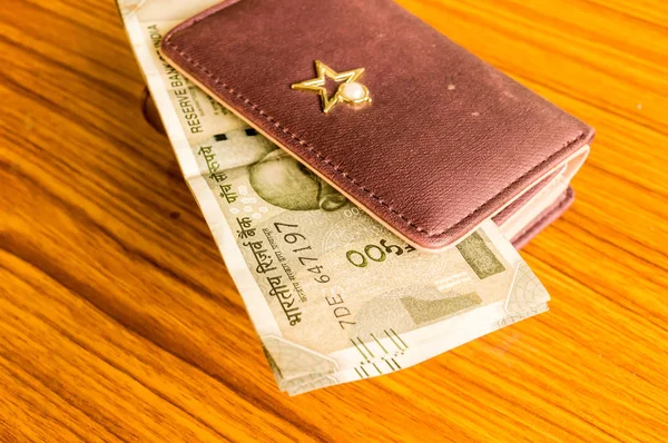 Indiske fem hundrede (500) rupee kontant note i brun farve tegnebog læder pung på et træbord. Erhvervsøkonomi koncept. Side engel visning med kopi plads til tekst på venstre side af billedet. - Stock-foto