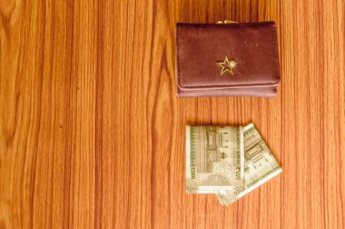 Ahşap bir masada kahverengi cüzdan deri çanta içinde Hint 500 rupisi nakit para. İş ekonomisi konsepti. Resmin sol tarafında metin için boşluk kopyalama odası olan kenar melek görünümü.