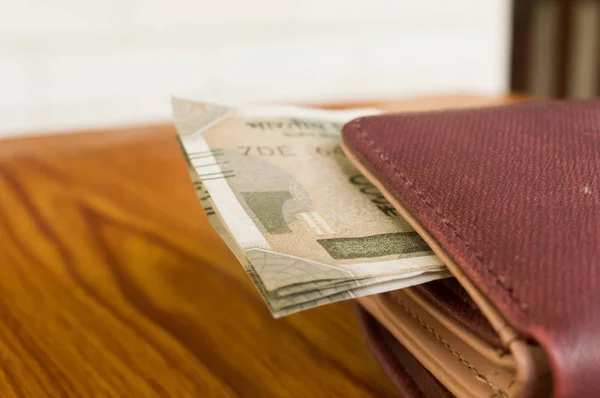 Indian five hundred (500) rupee cash note in brown color wallet leather purse on a wooden table. Business finance economy concept. Side angel view, extreme close up with copy space room for text. — Stock Photo, Image