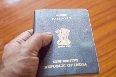 Ahşap masa parke zemin arka plan üzerinde seçici odak Hint pasaport defteri tutan adam. Yakın çekim. Seyahat turizm ve tatil tatil kavramı. Kopya metin için yer alan.