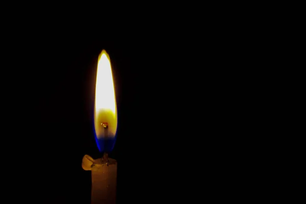 Una candela accesa su sfondo nero, da vicino . — Foto Stock