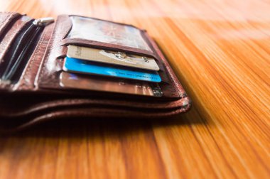 Seçici odak. Erkekler Deri Kahverengi açık cüzdan ahşap arka plan üzerinde izole. Metin veya nesne eklemek için oda.