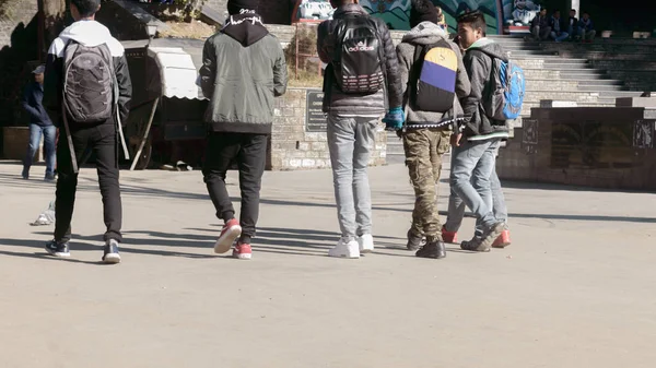 Darjeeling, India - Mayo de 2018: Grupo de amigos sonrientes caminando por la carretera durante el día. Vista trasera. Imagen recortada. La gente se divierte al aire libre. Concepto de feliz día de la amistad .. —  Fotos de Stock