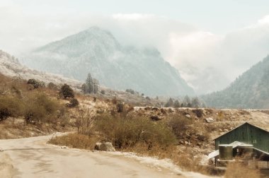 Kış Keşmir Hindistan'da karla kaplı bir dağa doğru giden uzun bir düz yol
