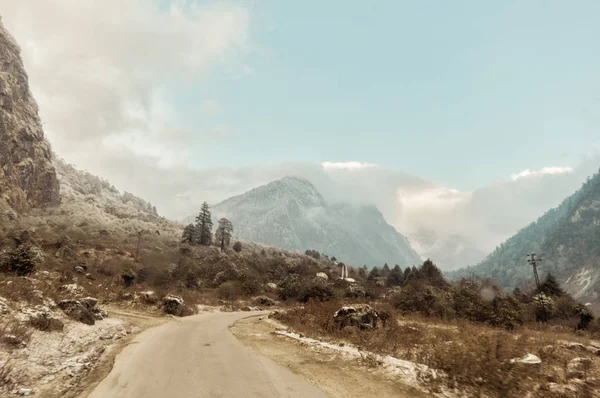 Eine lange gerade Straße, die im Winter zu einem schneebedeckten Berg in Kaschmir-Indien führt — Stockfoto