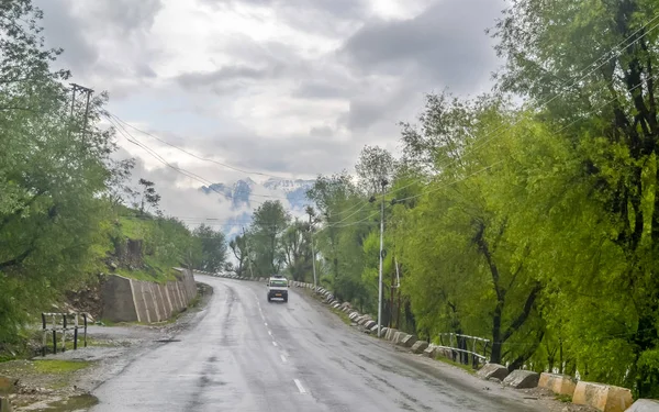 Perfecto camino de montaña de asfalto en días lluviosos nublados. Camino ascendente que conduce a través. Carretera con reflexión y pinos en Himalaya. Transporte. Carretera vacía en un bosque brumoso. Viaje de vacaciones . — Foto de Stock