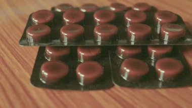 Kapsül yığınları kabarcıklar, yuvarlak desenli şekilli ilaç tablet veya ahşap masa arka plan üzerinde antibiyotik hapları paketlenmiş. Tıbbi Eczane teması. Kopyalama alanıyla kapat.