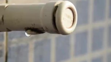 Suyun yakın çekim beyaz hortum borusundan sızıyor. Delikten su sızıntısı. İçme Suyu koruma ve Su tasarım elemanları kavramı kaydet Görüntü.