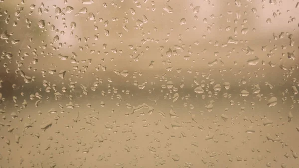 Rain Drops On Surface of wet Window Glass pane In Rainy Season. Abstract background. Natural Pattern of raindrops isolated from outdoor cloudy environment. — Stock Photo, Image