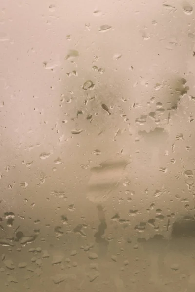 Rain Drops On Surface of wet Window Glass pane In Rainy Season. Abstract background. Natural Pattern of raindrops isolated from outdoor cloudy environment. — Stock Photo, Image
