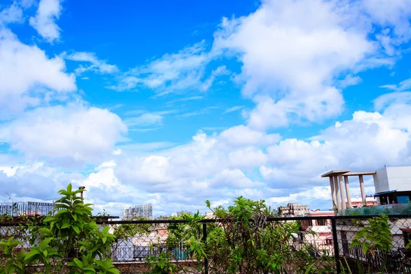 Nubes en la azotea de la casa y edificio alto en Calcuta, India. Ciudad moderna horizonte plano fondo panorámico con diminutas nubes flotando en el cielo a la luz del día . — Foto de Stock