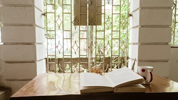 Café et réservation par fenêtre un dimanche matin. Livre de lecture en plein soleil du matin. Hygge humeur estivale. Vacances, loisirs, littérature et concept de détente . — Photo