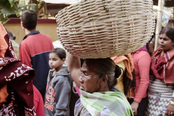 Birbhum district, Bolpur, West Bengal, India 1 de mayo de 2018 - Una vieja vendedora de mercado activa de Bengalí mayor que lleva una cesta en la cabeza en el área del mercado de bazar de Sona jhuri Haat en el día internacional de los trabajadores . — Foto de Stock