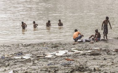 Kalküta, Batı Bengal, Hindistan 15 Ekim 2018 - Ganj Ghat (Hooghly) Nehri'nin kirli kıyısında yıkanan insanlar. Ulusal Yeşil Mahkeme Ganj su tüketim için uygun olmadığını gösterir rağmen 