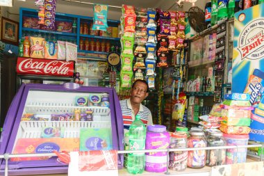 Kalküta, Batı Bengal, Hindistan 1 Ocak 2019 - Bir perakende bakkal dükkanı sahibi kendi mağazası nın içinden müşteri arıyor.