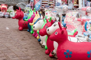 Kolkata 'daki Kordon Yolu yakınlarındaki New Market El Sanatları Mağazası' nda öğleden sonra güneşinde sergilenecek renkli plastik oyuncaklar ve bebekler üretiliyor. Lacquer ahşap kaplama Parlak bir görünüm verir.