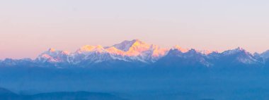 Panorama of majestic Mount Kanchendzonga range of himalayas at first sunrise from Tiger Hill. First ray of sun struck mountain starting beautiful day on entire nature around. Darjeeling, Sikkim, India clipart