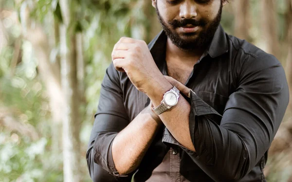 Portrait of Cropped Homme bien habillé portant une montre-bracelet et retroussant les manches de chemise. Vue de face. Un look élégant. Mode Textile Contexte de l'industrie . — Photo