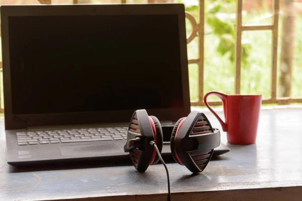Bilgisayar için Mikrofon Gürültüsü İptal ve Ultrasonik Ses Ayarlayıcı Kulaklık ile taşınabilir Binaural Sound USB kulaklığı, Skype sabahleyin pencere güneşinin yanına dizüstü bilgisayar yerleştirdi. Uzaktan bir fincan kırmızı kahve. Evde kal, evden çalış, R