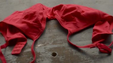 Kırsal metalik zeminde kırmızı sütyen. Romantik tutkulu kadın iç çamaşırı. Seksi moda geçmişi. Hareketsiz video görüntüleri.