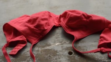 Kırsal metalik zeminde kırmızı sütyen. Romantik tutkulu kadın iç çamaşırı. Seksi moda geçmişi. Hareketsiz video görüntüleri.
