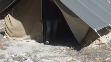Dağlarda kamp yapmak. Gezgin bir kadın Hiker turist yaz mevsiminde doğa yürüyüşü yaparken dağ vadisi yakınlarında kurulan bir çadırdan çıkıyor. Seyahat turizmi kampı. 