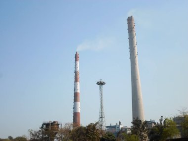 Fabrika bacası, endüstriyel bacalar, uzun endüstriyel fabrika bacaları Kolkata Batı Bengal Hindistan Güney Asya Pasifik 'in Ganj nehir kenarındaki jute mill sanayii bacaları.