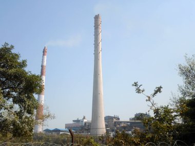 Fabrika bacası, endüstriyel bacalar, uzun endüstriyel fabrika bacaları Kolkata Batı Bengal Hindistan Güney Asya Pasifik 'in Ganj nehir kenarındaki jute mill sanayii bacaları.