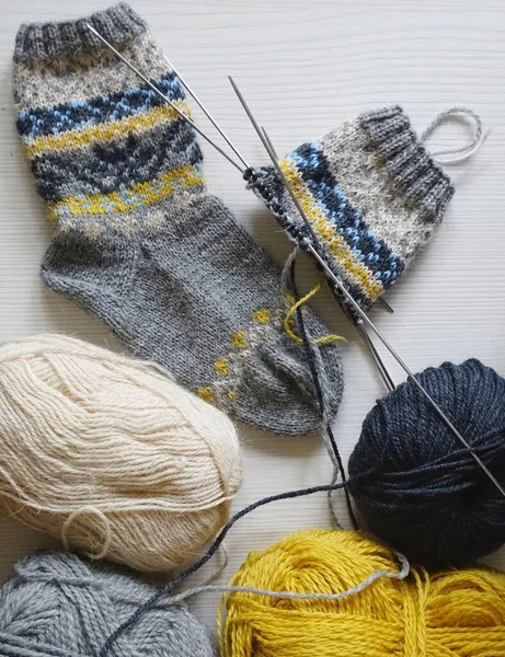 Processen med at strikke varme sokker med et mønster af uldgarn - Stock-foto