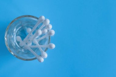 Pamuk tomurcukları, mavi bir arka plan üzerinde pamuk temizleme bezi. Medikal Kozmetik ve hijyenik aksesuarları.