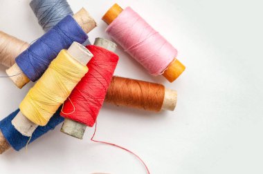 Beyaz bir arka plan üzerinde renkli iş parçacığı makaraları