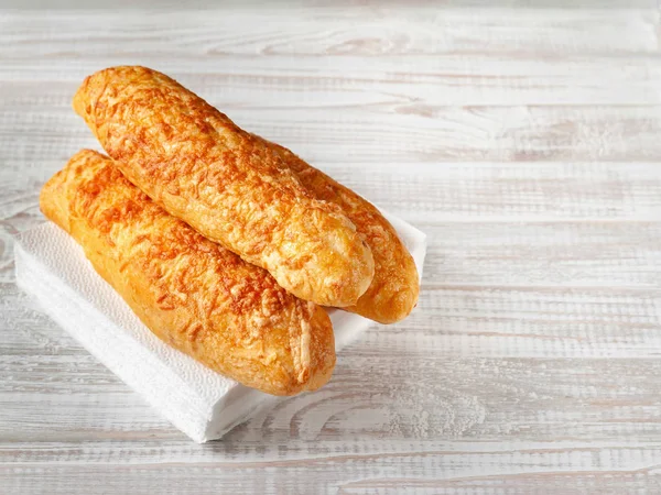 Cheese buns, bread with cheese on a white wooden background. Copy space