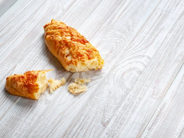 Peynirli çörek, ekmek peynir ile beyaz bir ahşap arka plan üzerinde kırık. Kopya alanı