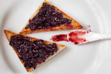 Kızamık reçel ve bir kaşık beyaz tabakta tost ekmeği