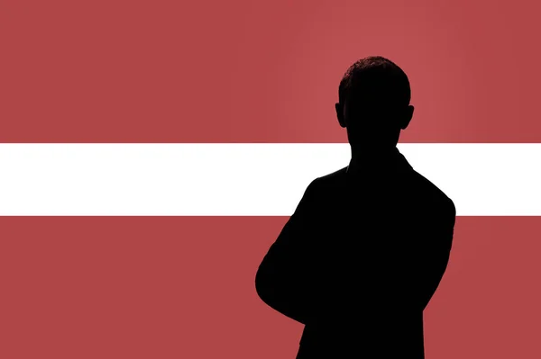 Silhouette d'homme d'affaires sur le fond du drapeau letton . — Photo