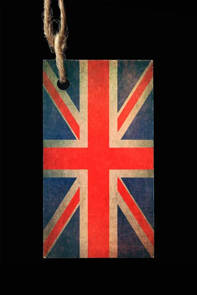 Kartonetikett in der Farbe der alten britischen Flagge mit einem Faden auf schwarzem Hintergrund. — Stockfoto