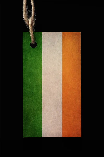 Kartonnen etiket in kleur van de vlag van Ierland met een draad op een zwarte achtergrond. — Stockfoto