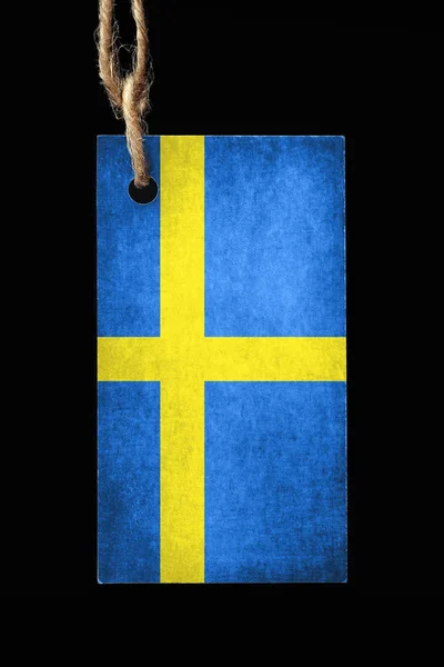 Cardboard label in color of the flag Sweden with a thread on a black background. — Stock Photo, Image
