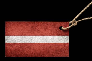 Bir iş parçacığı üzerinde siyah bir arka plan ile Letonya bayrağı renkli karton etiket.