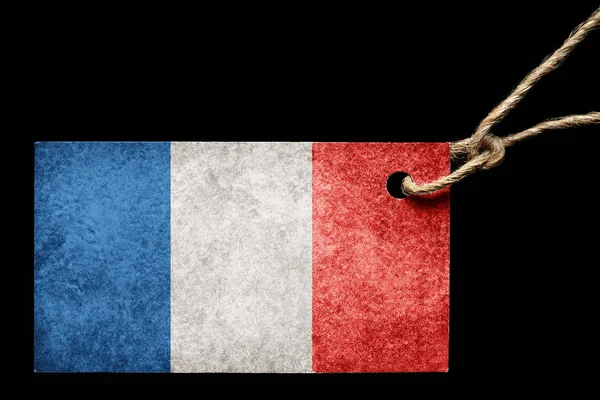 Ετικέτα από χαρτόνι στο χρώμα της σημαίας της Γαλλίας με ένα νήμα σε μαύρο φόντο. — Φωτογραφία Αρχείου