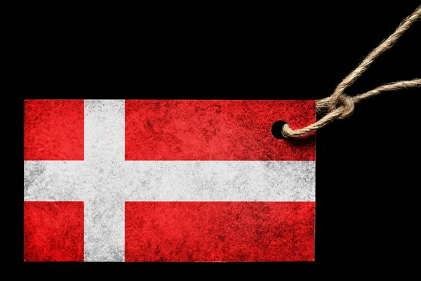 Ετικέτα από χαρτόνι στο χρώμα της σημαίας της Δανίας με ένα νήμα σε μαύρο φόντο. — Φωτογραφία Αρχείου