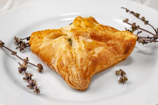 Fresh bun with vegetable filling and dried spice on a white plate. — Stock Photo, Image