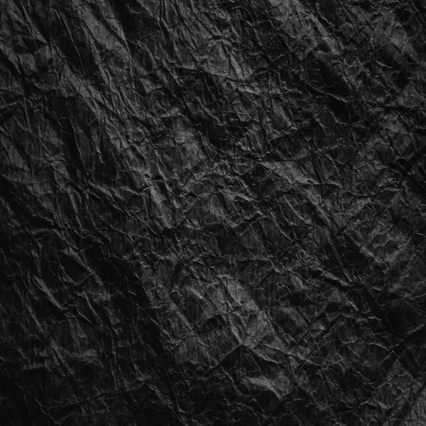 Crumpled black kraft paper. Texture of crumpled black recycled paper. The concept of recycling and reuse of paper and garbage. — Stock Photo, Image